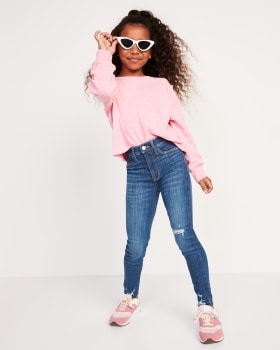 A young model wearing a pink fleece and a jegging jeans.