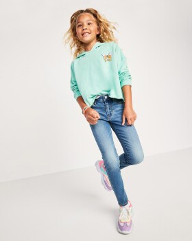 A young model dressed in a light green sweatshirt and a super skinny jeans.