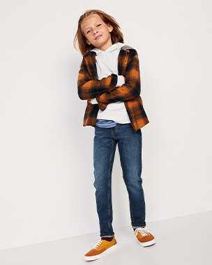 A model wearing white fleece, orange and black patterned shirt and taper jeans.