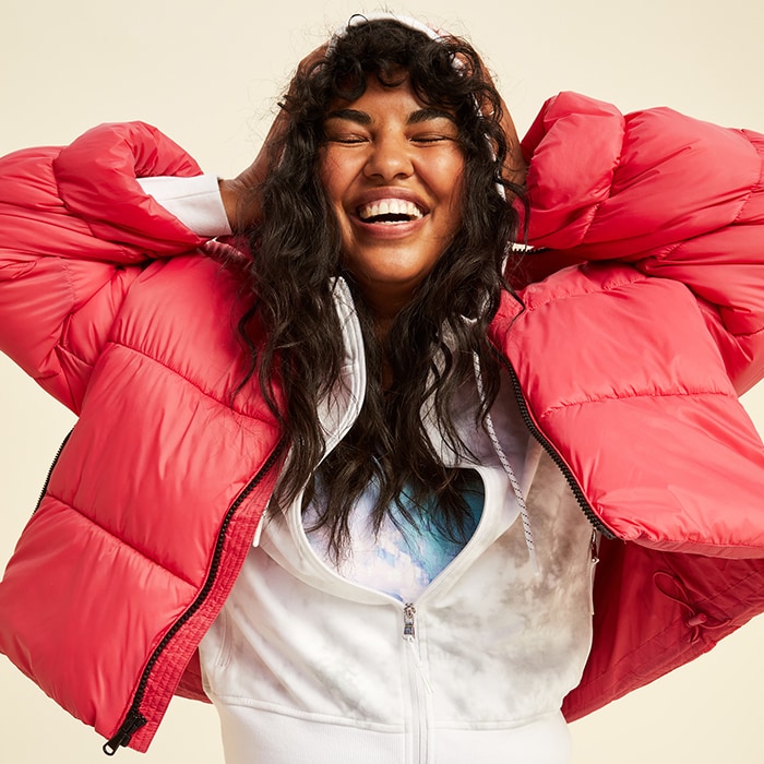 A female model wears a  water-resistant frost free short puffer jacket over a white zip-up hoodie