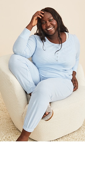 A female model wears a light blue long-sleeve waffle-knit henley pajama t-shirt and matching high-waisted thermal jogger lounge pants