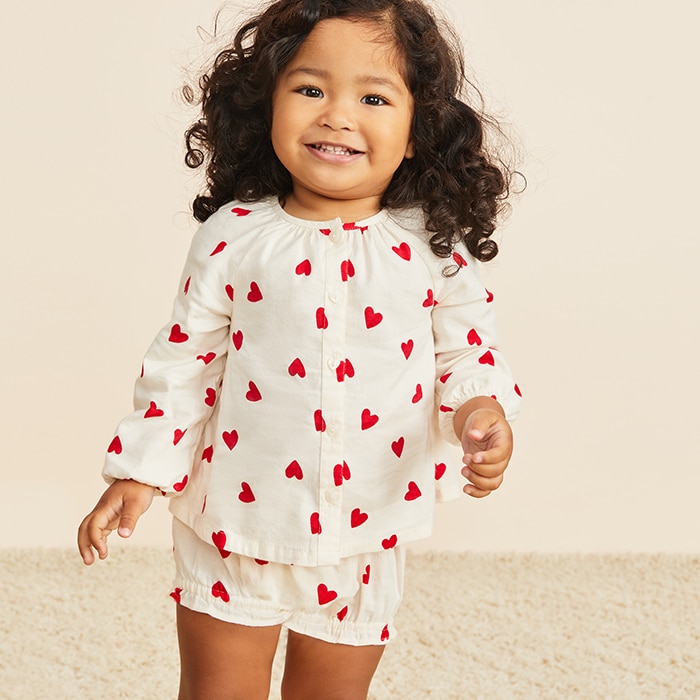 A young female model wearing matching white heart patterned set.