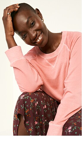 A female model wears a pink colored vintage specially dyed crew-neck sweatshirt and long floral skirt