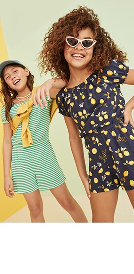 Two female models in shorts rompers. One is striped, and the other has a lemon pattern.