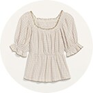 A beige flowy prairy blouse with 3/4 ruffle sleeves.