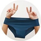 Image of model's hands holding up a pair of dark blue hipster style underwear.