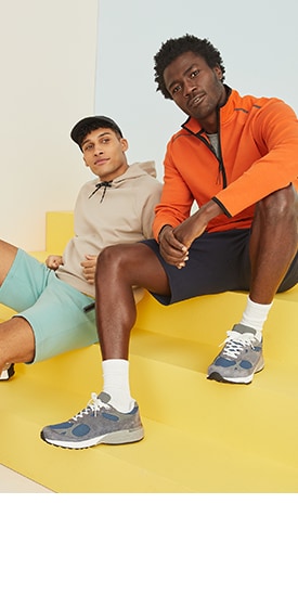 Two male models wear activewear outfits.