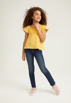A female model wears Skinny style jeans with a yellow top.
