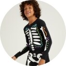 A young model wearing a skeleton themed pajama set.
