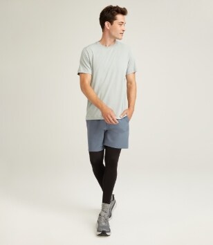 A male model wears dark base layer legging with his activewear outfit.