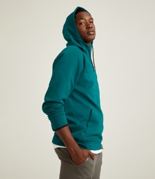 A male model wears teal activewear hoodie.