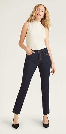 A female model in medium rise black wash slim jeans.