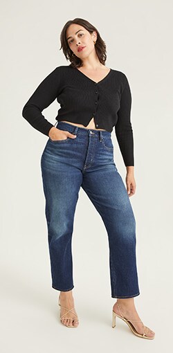 A model in a pair of light wash straight leg raw hem jeans.