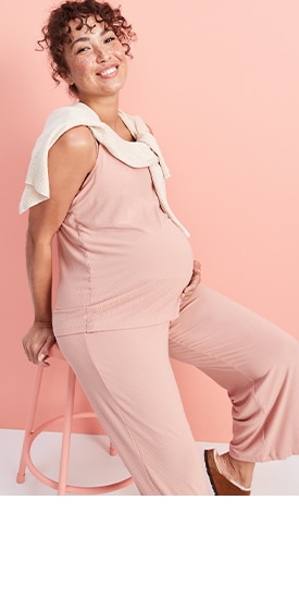 A maternity model wears a light pink Sunday Sleep Ultra-Soft Nursing Cami Top & matching Rollover-Waist Ultra-Soft Sunday Sleep Jogger Pants.