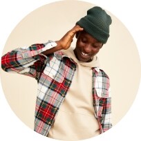 A male model wearing a holiday plaid flannel shirt