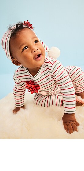 A baby model wearing striped pajamas and cap.