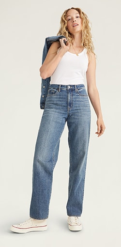 Model in dark-wash loose boyfriend style jeans.