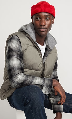A male model wears a plaid shirt with a grey puffer vest.