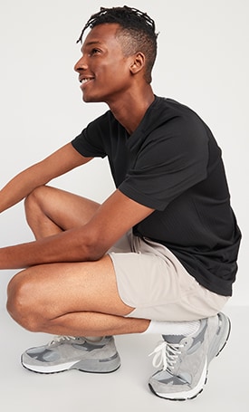 A male model wears a dark colored Go-Fresh Odor-Control Seamless Performance T-Shirt & light colored activewear shorts