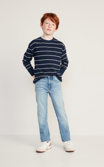 A young model wearing light stretch jeans and stripped long sleeve crew neck shirt.