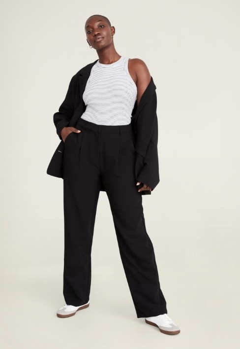 A female model wearing dark colored Taylor Trouser style pants