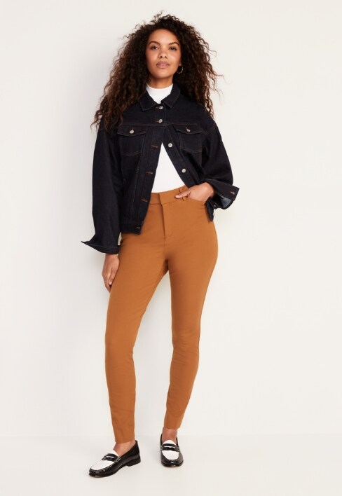 A female model wearing orange colored Pixie Skinny style pants