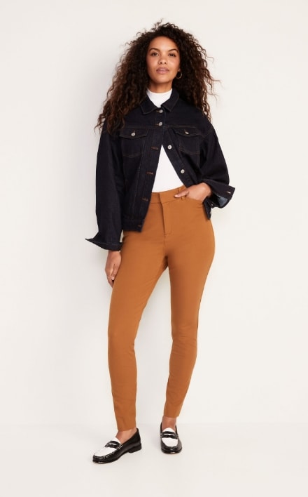 A female model wearing orange colored Pixie Skinny style pants