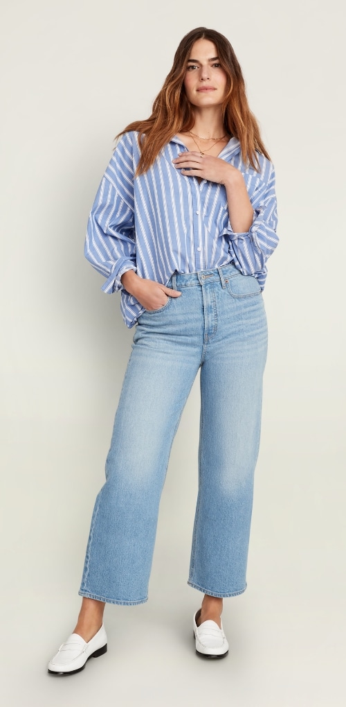 A female model wearing extra high waisted cropped wide leg jean and stripped shirt.