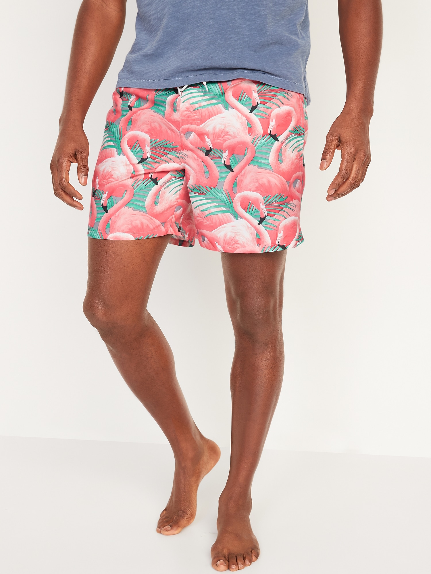a man wearing flamingo print swimming trunks